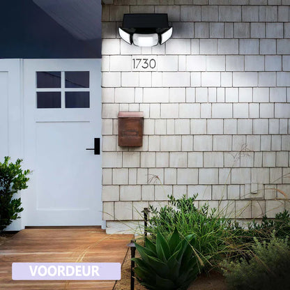 Solar LED wandlamp met bewegingssensor bevestigd aan een buitengevel van een woning