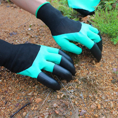 Twee handen met tuinhandschoenen aan, bezig met het planten of wieden van onkruid in de aarde.